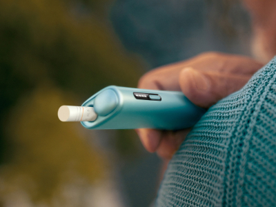 يد تمسك بجهاز IQOS ILUMA i ONE